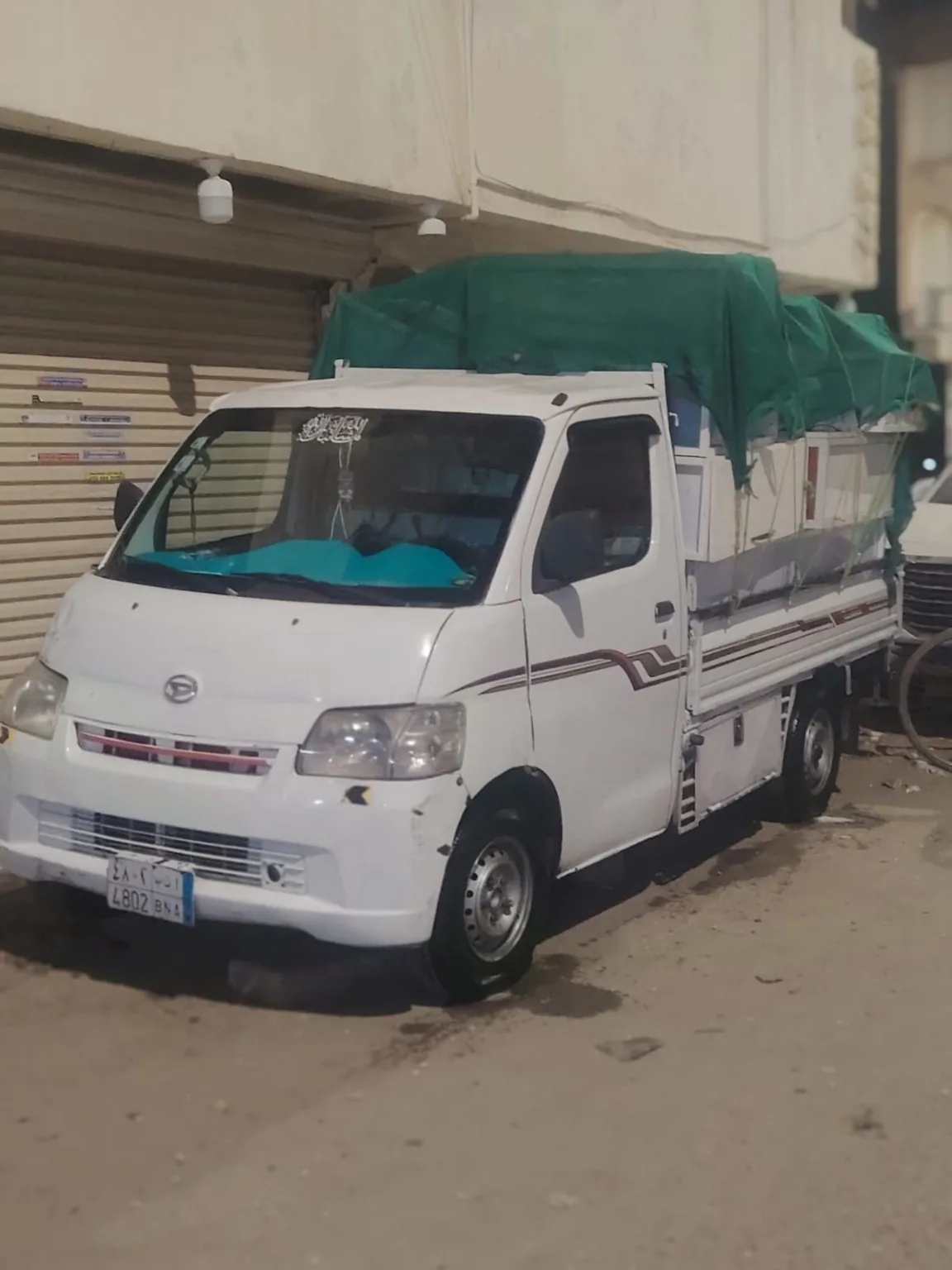 سيارة نقل عفش محملة ومغطاة